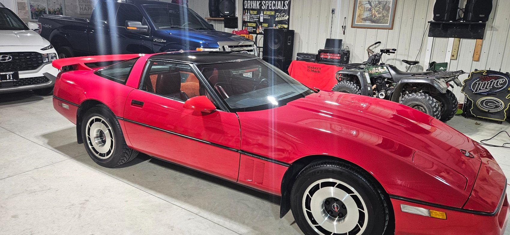 Red Corvette looking polished inside a garage